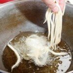 Lower the dough gently into the boiling oil